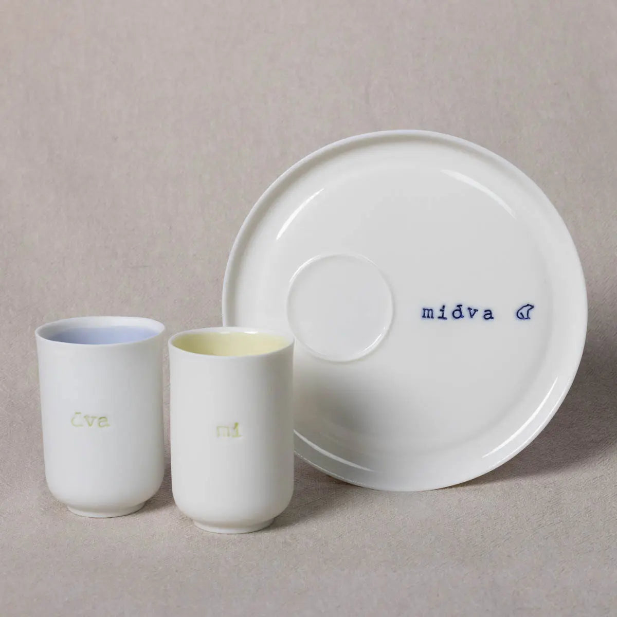 A white plate with the "Urchic Porcelain" brand name and a symbol, accompanied by two Snow White *Soulmates* cups labeled "ti" and "jaz," set against a neutral background.