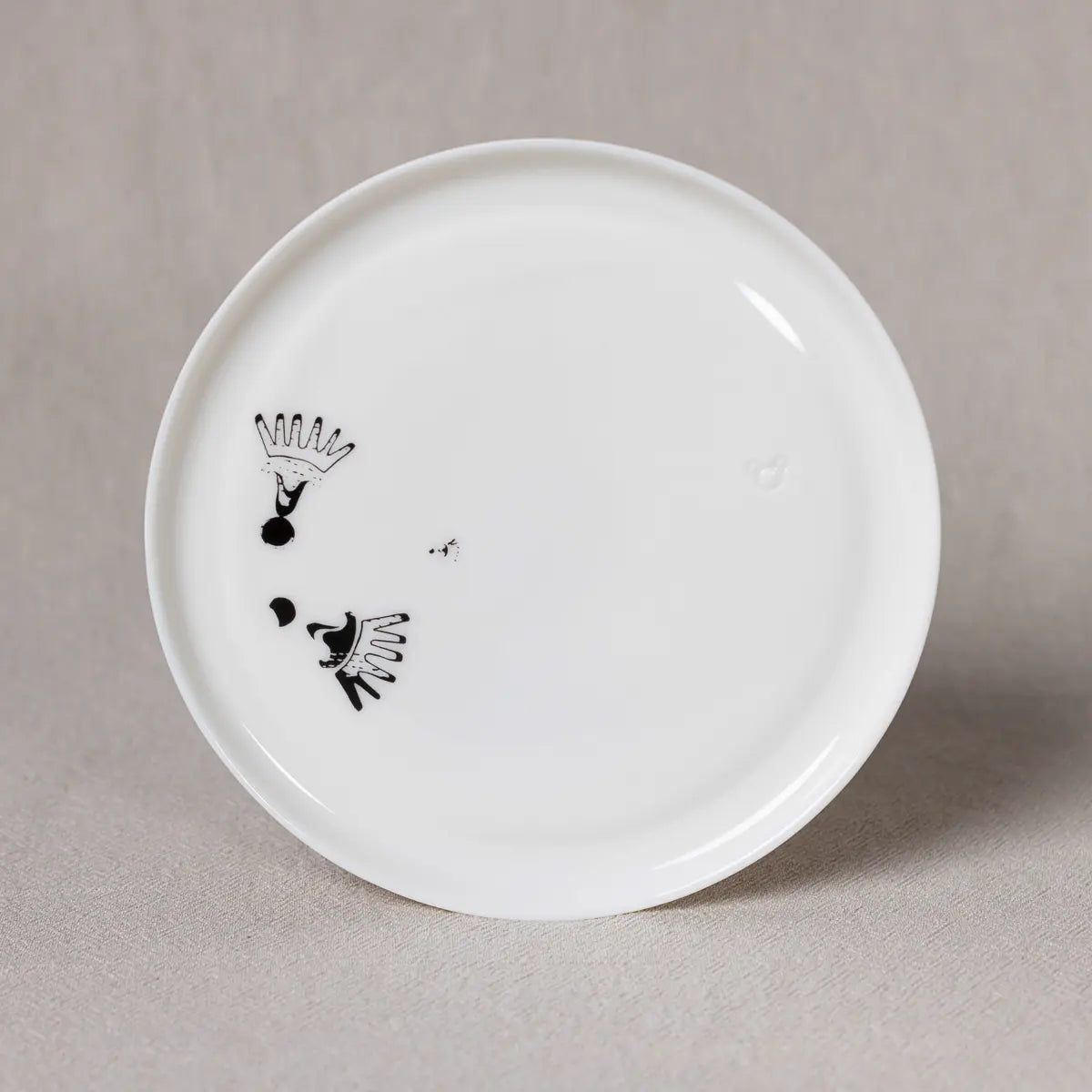 The Breakfast or Dinner Plate from Urchic Porcelain, featuring the Vurnik Carnation pattern, showcases a minimalist black abstract design of lines and dots on a plain white medium porcelain surface. This elegant piece, inspired by Rebeka Mamič's black & white carnation pattern, brings sophistication to any dining setting.